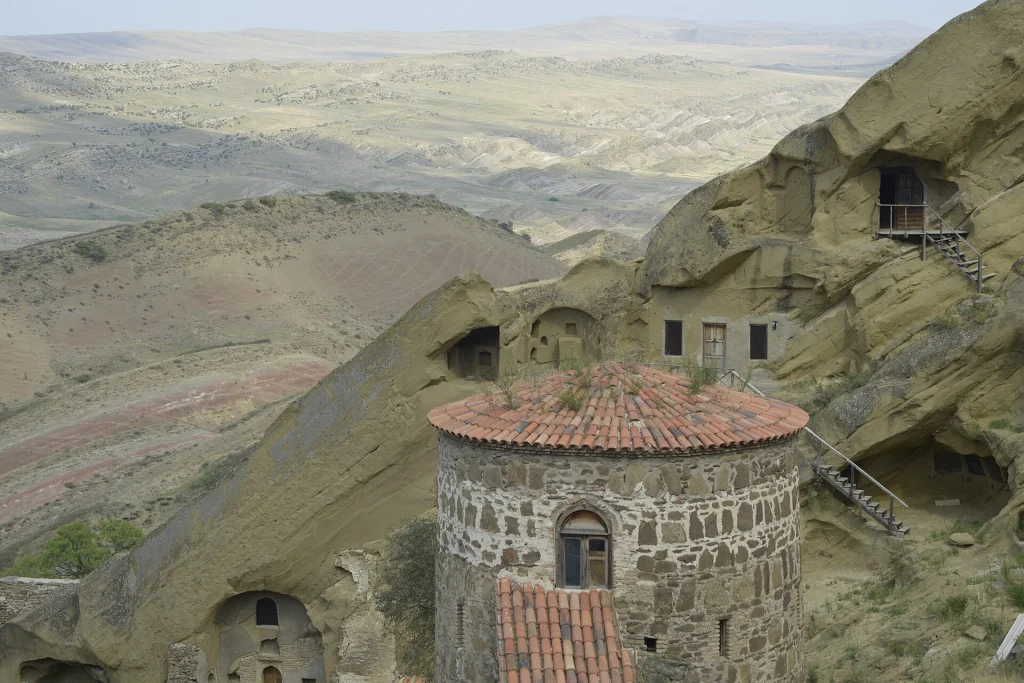 Red-roofed cave monastery tower overlooking the semi-desert landscape of David Gareja.