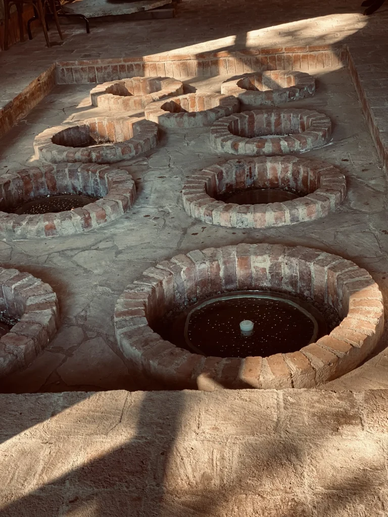 Barakoni Winery — Traditional qvevri clay wine vessels embedded in a stone cellar floor.