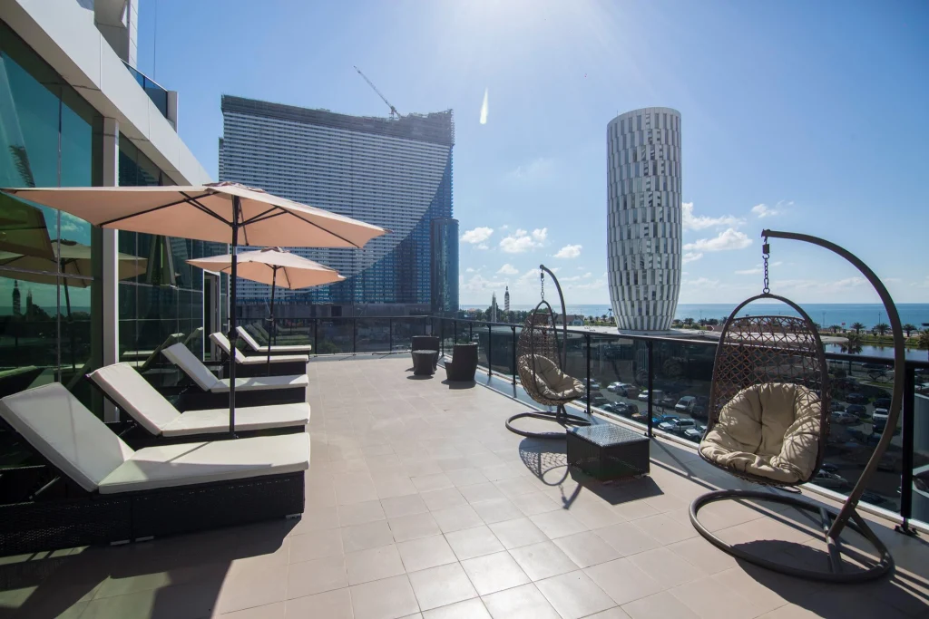 Best Western Premier Batumi — Rooftop terrace with loungers, swing chairs, and panoramic city and sea views.