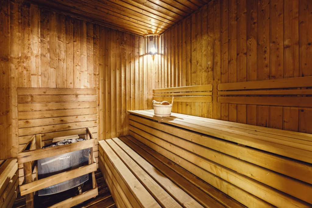 Crystal Hotel & Spa — Traditional wooden sauna room with benches and a wood-fired heater.