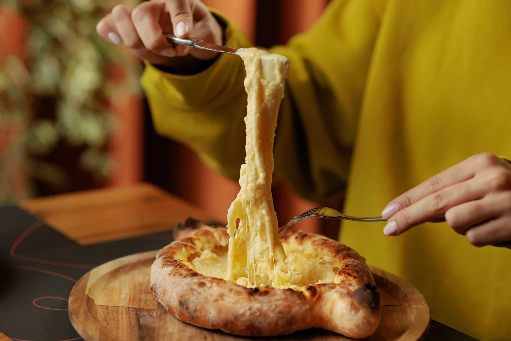 Dialog Kokhta Bakuriani — Close-up of a cheese-filled khachapuri being served at the restaurant.