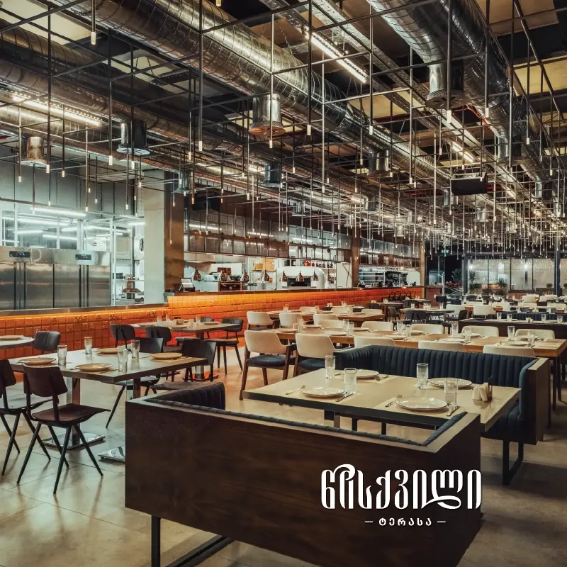 Ethno Tsiskvili — Spacious industrial-style restaurant hall with exposed ductwork and open kitchen.