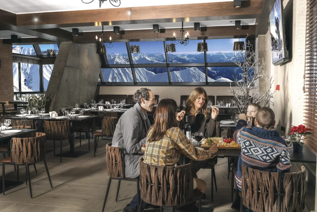 Gudauri Hills Residence — Restaurant dining area with guests seated at tables and panoramic mountain views.