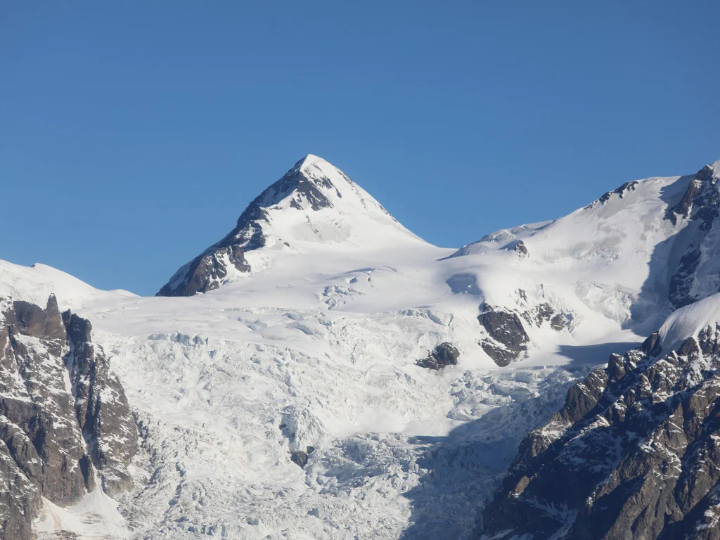 Hotel Gistola In Mestia — Snow-capped mountain peak and glacier visible under clear blue sky near the property.