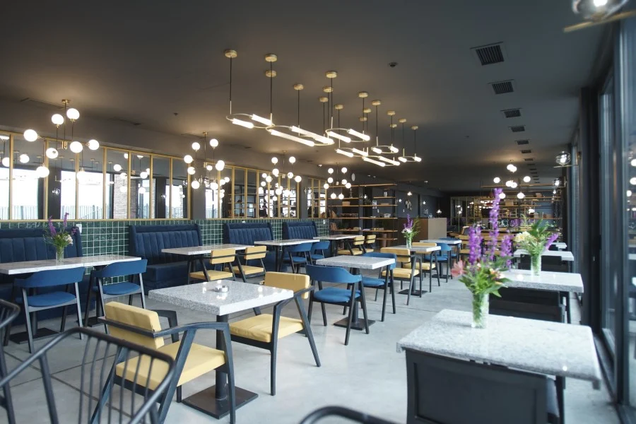 Hotel Memoir Kazbegi — Spacious hotel restaurant with blue booth seating and modern pendant lighting.