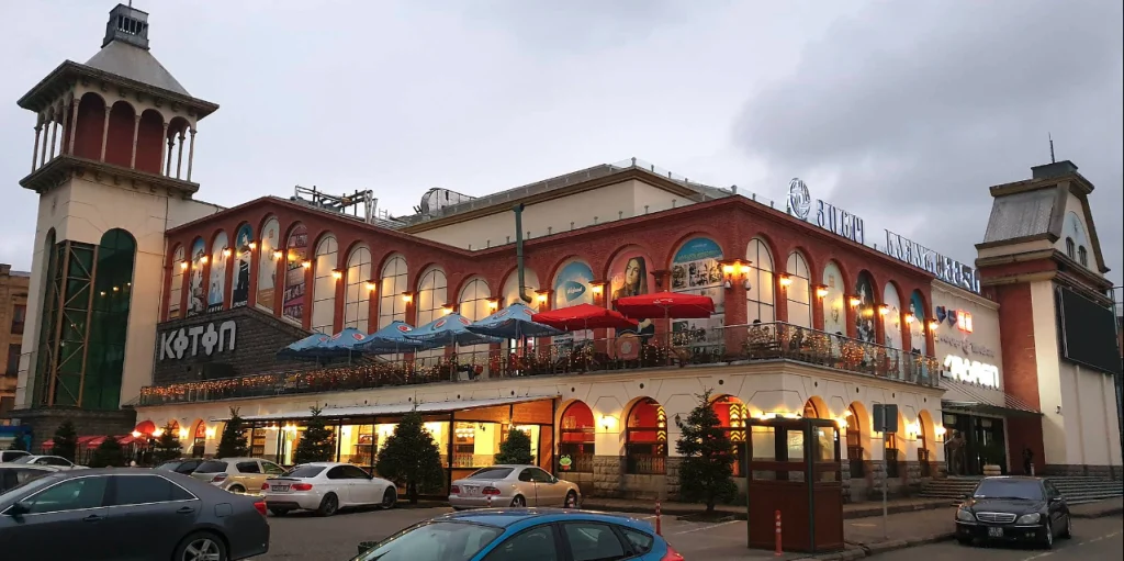 Maharajah Restaurant (Tbilisi) — Building exterior at dusk with illuminated arched windows and rooftop terrace seating.