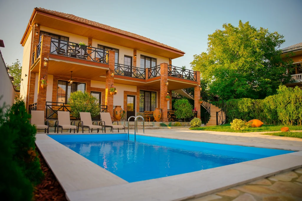 Merebashvili Estate — Two-story estate building with balconies overlooking a private outdoor swimming pool.