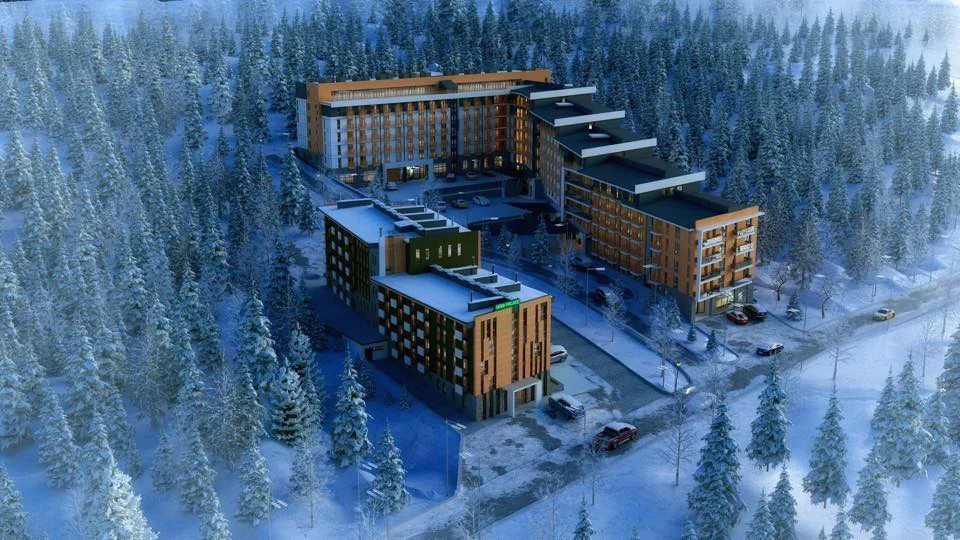 Orbi Palace Hotel Bakuriani — Aerial winter view of the hotel's multi-building complex surrounded by snow-covered pine forest.