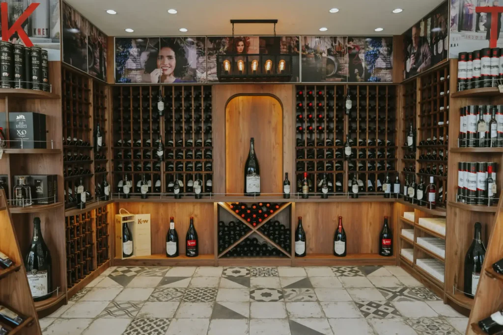 Patardzeuli Wine House — Wine cellar room lined with wooden racks and bottles for display and tasting.