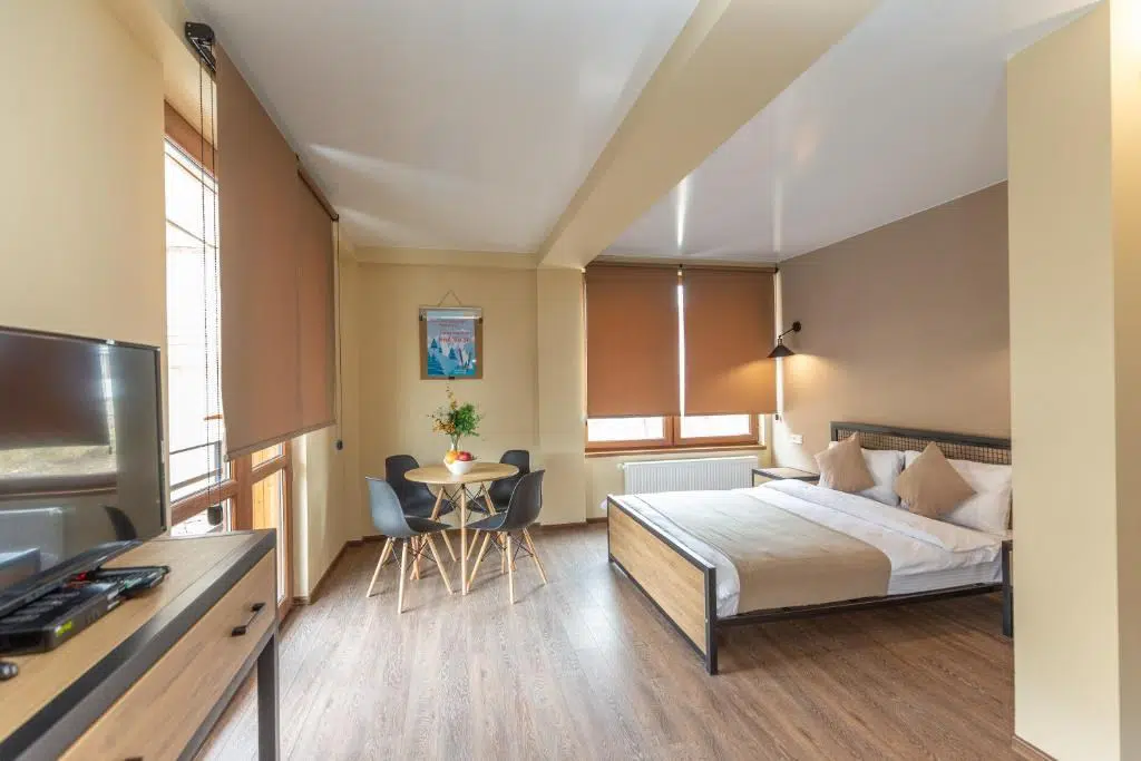 Pine Chalets By KA Group — Bright guest room with double bed, seating area and dining table.