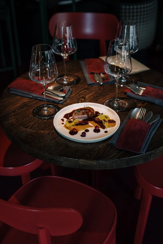 Restaurant Darbazi — Elegant table setting with wine glasses and a plated dish in a dim dining room.