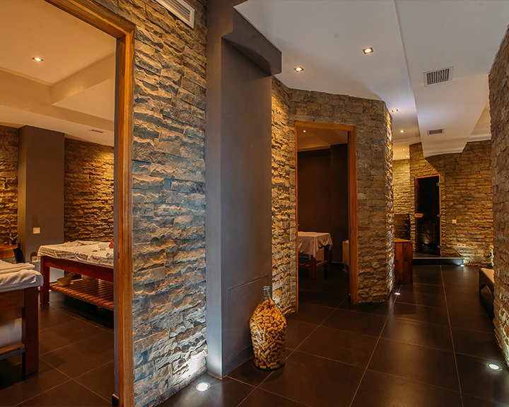 Schuchmann Wines Chateau,  Villas & Spa — Stone-walled spa corridor with warm lighting leading to treatment rooms.