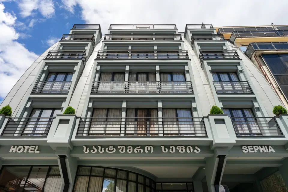 Sephia — Multi-story hotel facade with balconies and signage viewed from the street below.