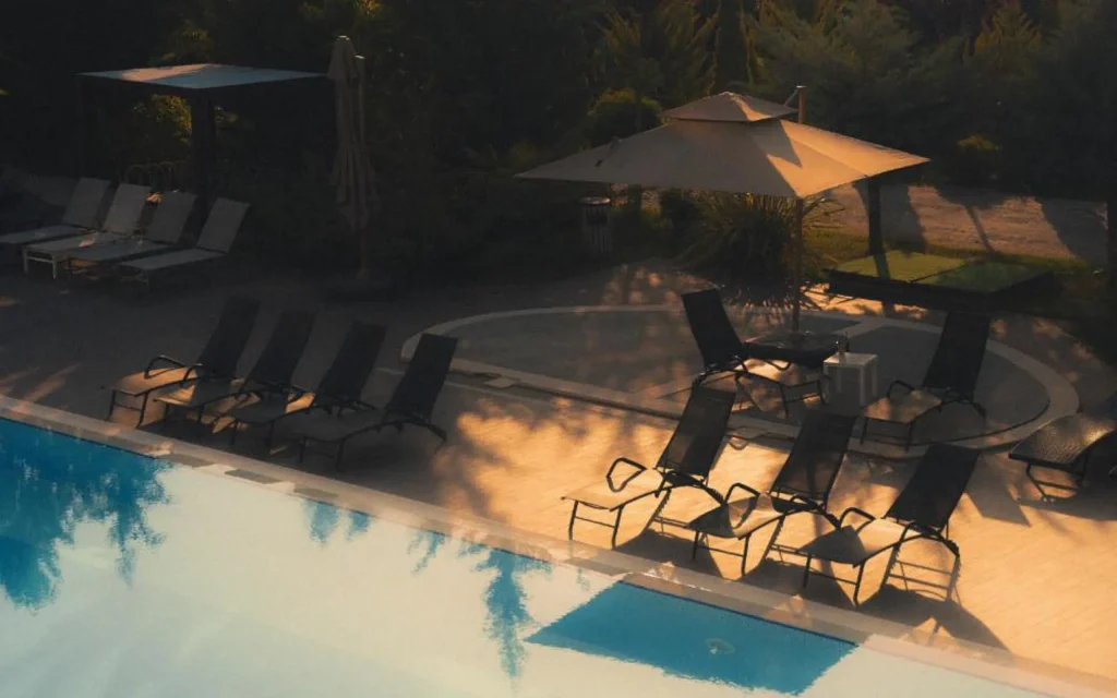 Sevsamora Resort & Spa — Outdoor pool area with sun loungers and umbrellas at golden hour.