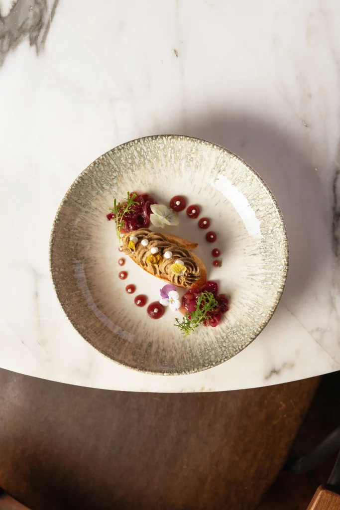Shua Kalaki Arena — Close-up of a gourmet plated dessert on a marble table.