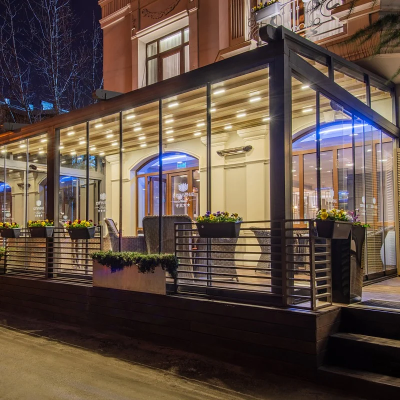 Tbilisi Chambers, Trademark Collection by Wyndham — Glass-enclosed terrace restaurant on the building's exterior, illuminated at night.