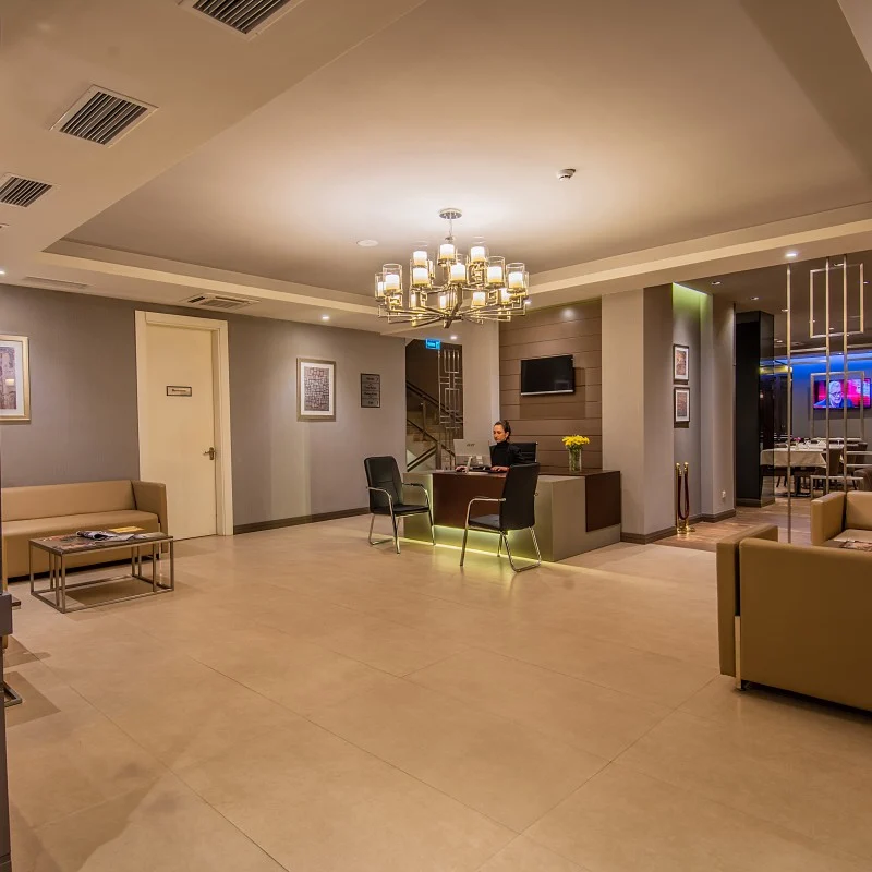 Tbilisi Chambers, Trademark Collection by Wyndham — Hotel lobby with reception desk, chandelier, and seating area.