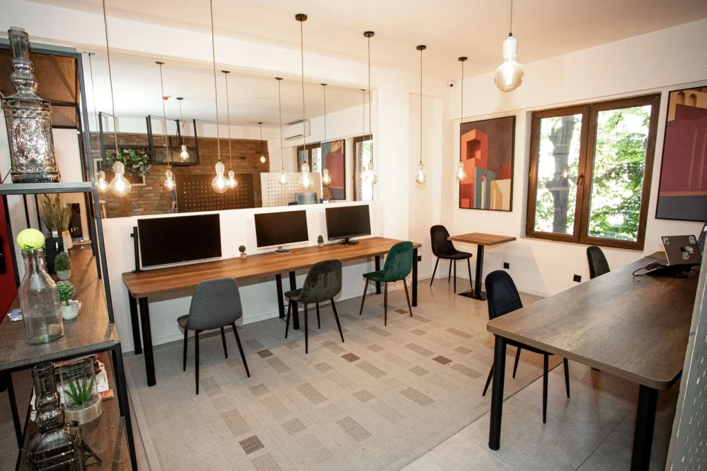 The Tbilisi Pod — Lounge and co-working space with desks, computer monitors, and modern lighting fixtures.