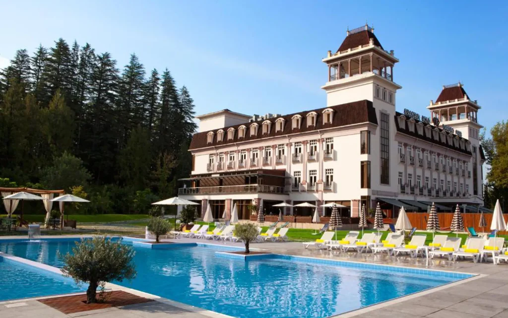 Tskaltubo Plaza — Outdoor swimming pool with loungers set before the hotel's grand exterior.