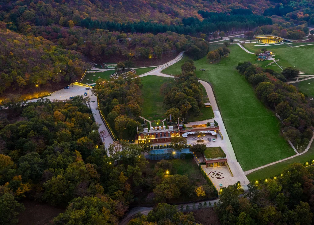 Wellness Resort BIOLI — Aerial daytime view of the resort buildings surrounded by forest and green lawns.