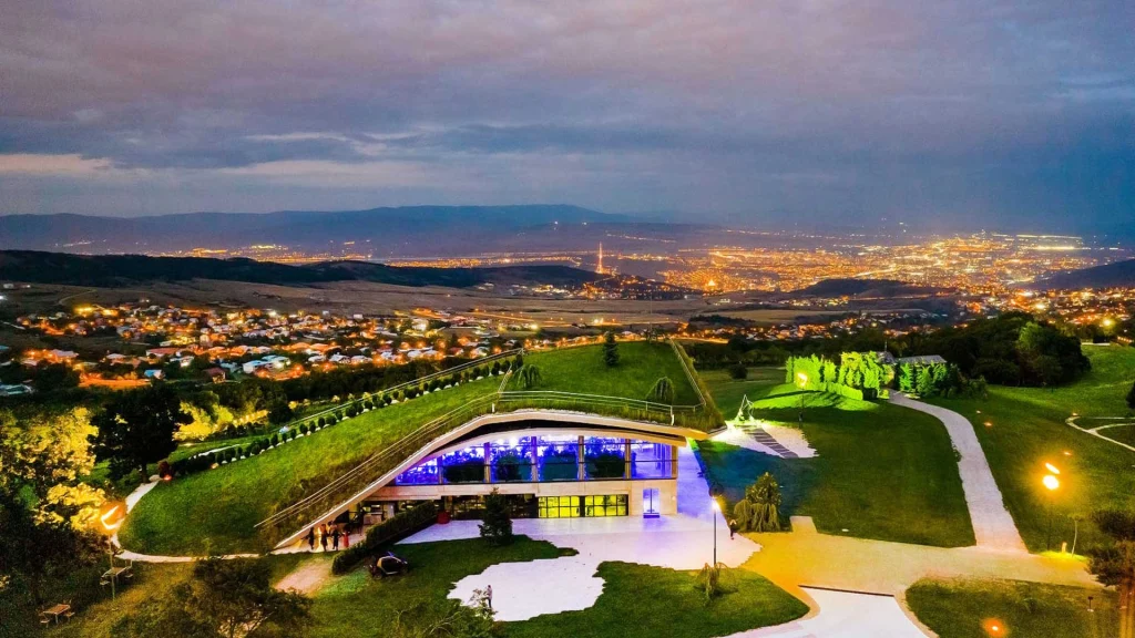 Wellness Resort BIOLI — Night view from the hillside resort overlooking an illuminated valley and city lights.