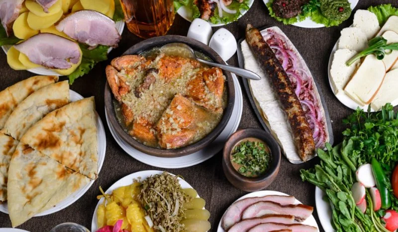 Winery Solomone — Overhead spread of assorted local dishes, bread, meats, and cheeses on a table.