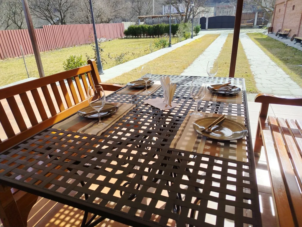 Winilia Winery — Outdoor dining terrace with set table overlooking a landscaped garden and pathway.