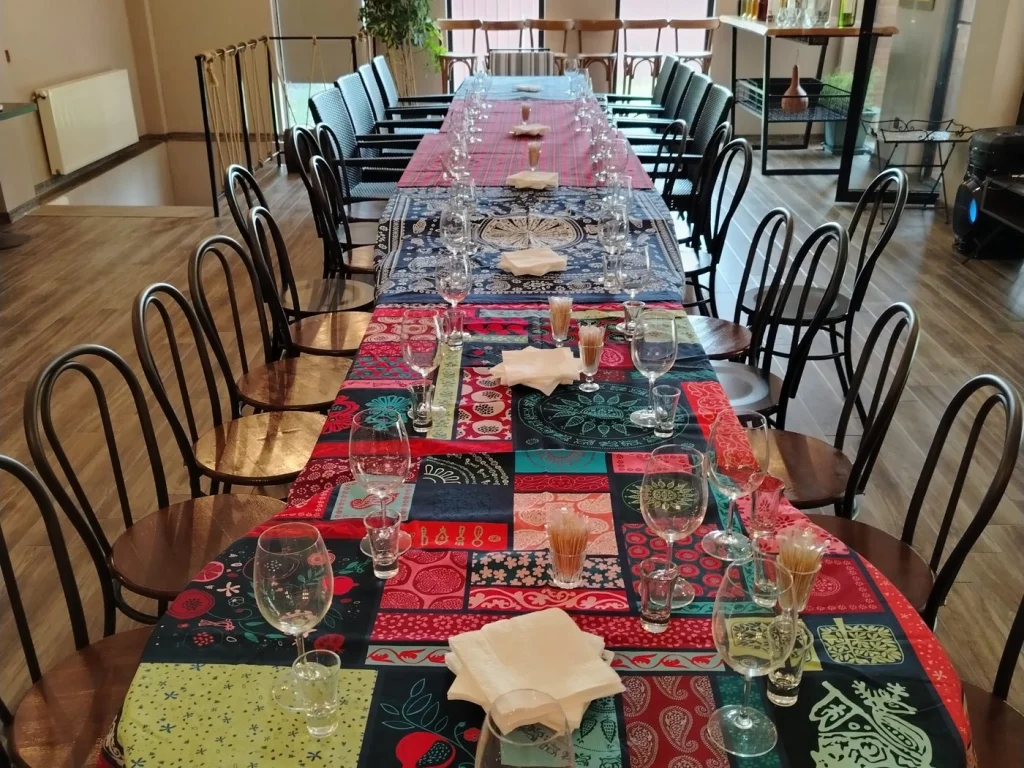 Winilia Winery — Long dining table set with wine glasses and patterned linens inside the restaurant.