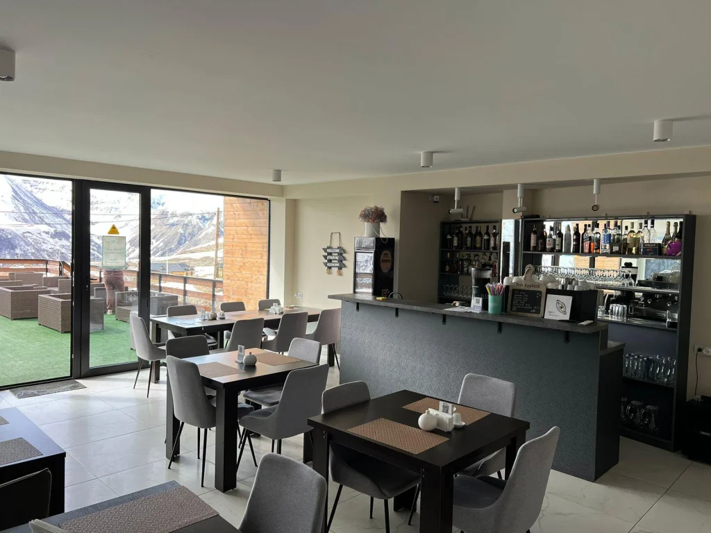 gudauri diamond — Hotel restaurant with dining tables, a bar counter, and mountain-view windows.