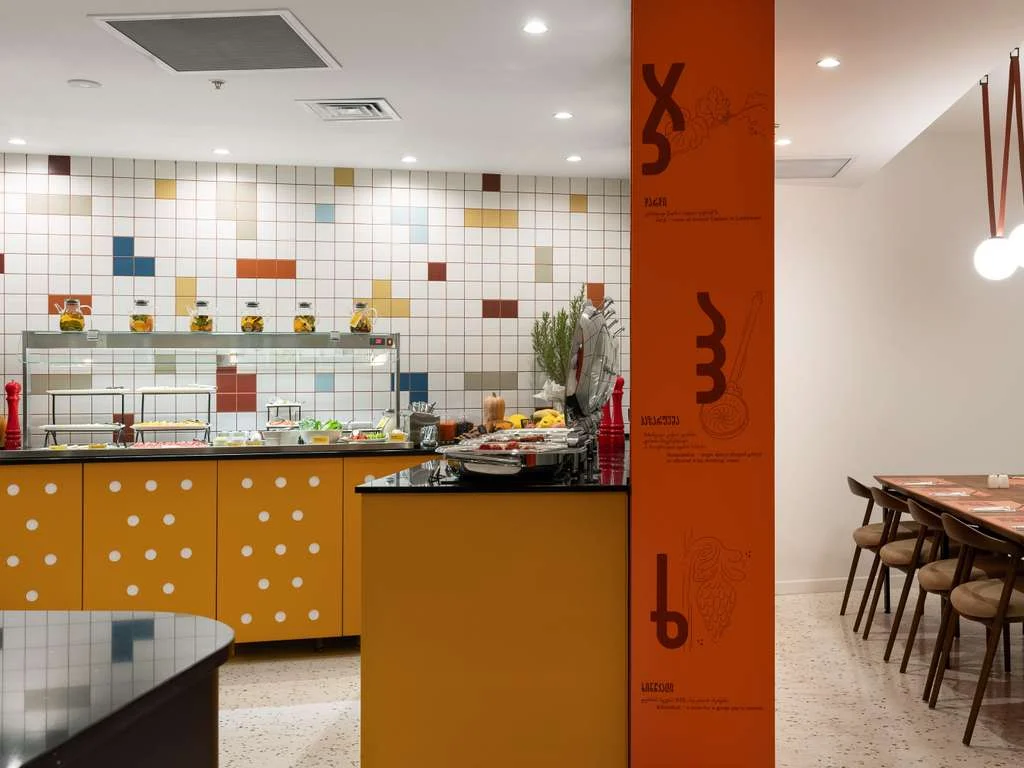 ibis Styles Old Tbilisi — Hotel restaurant area with buffet counter and dining tables.