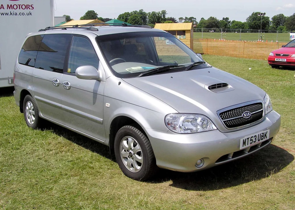 A silver Kia Sedona minivan, similar to vehicles used for private airport transfers.