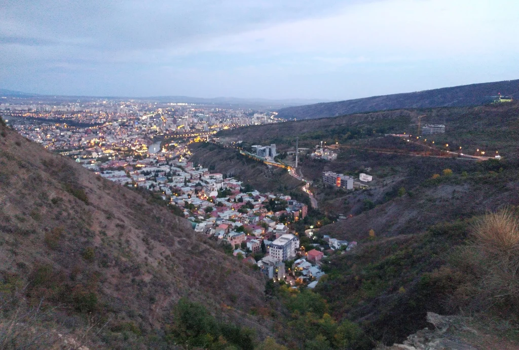 A twilight panorama of Tbilisi's Sololaki district seen from the Mtatsminda trail.