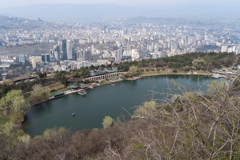 A scenic view of Turtle Lake, Tbilisi, with calm water and surrounding greenery.
