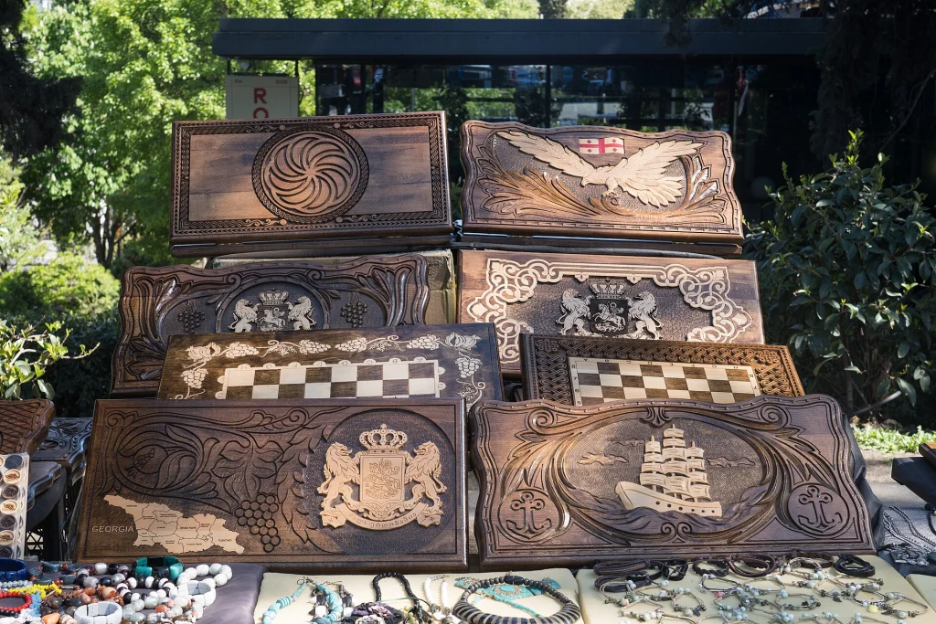 Hand-carved wooden backgammon boards with national motifs for sale at the Dry Bridge Market.