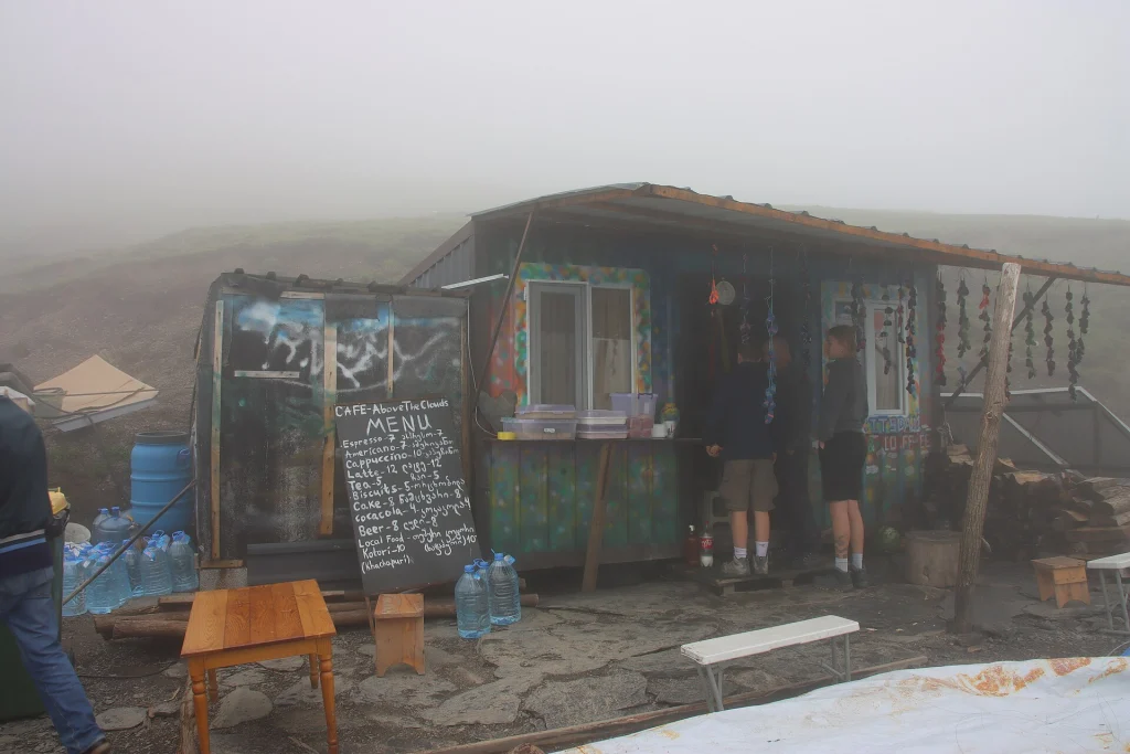 Travellers stop at a small roadside café amid fog at Abano Pass.
