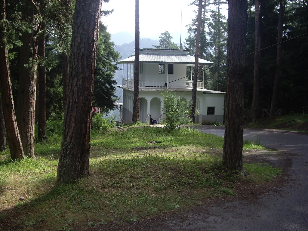 A building of the Evgeni Kharadze Abastumani Astrophysical Observatory among pine trees.