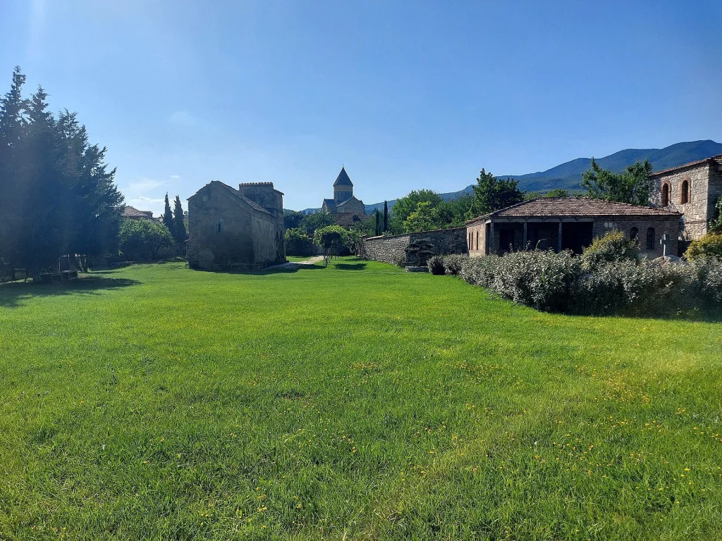 Green lawn leading to Antiochia church with Svetitskhoveli Cathedral in the background, Mtskheta.