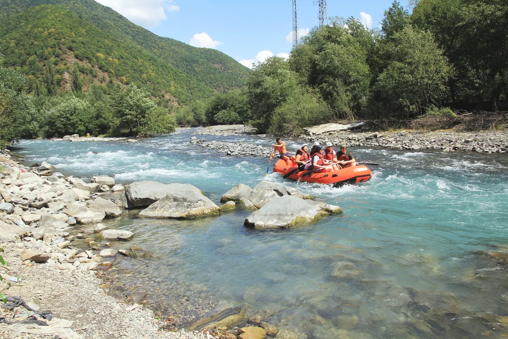 A raft full of tourists runs rapids at the Aragvi confluence.
