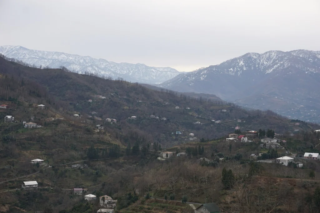 Adjara's mountain villages seen from above near Batumi, amid snow-capped peaks.