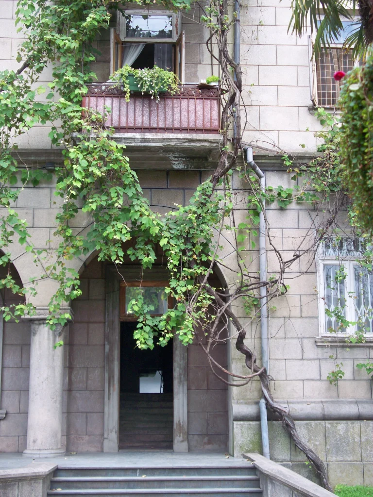 A historic building facade covered in vines in Batumi, Georgia.