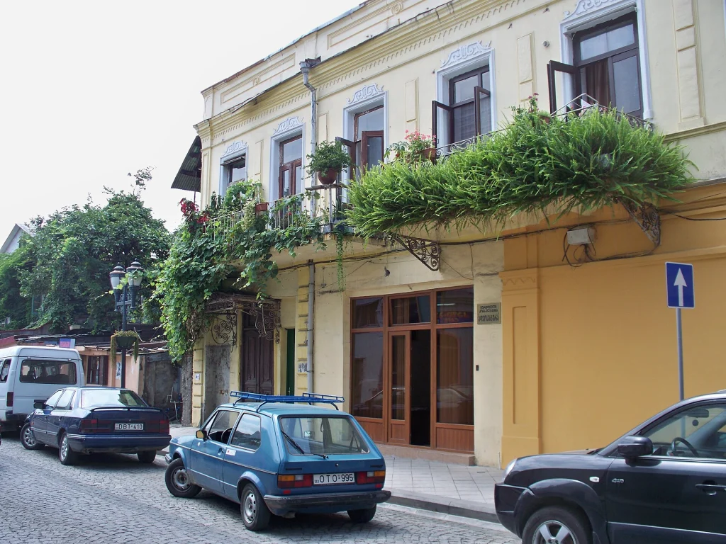 A street scene in Batumi, Georgia, showing historic facades and parked cars.