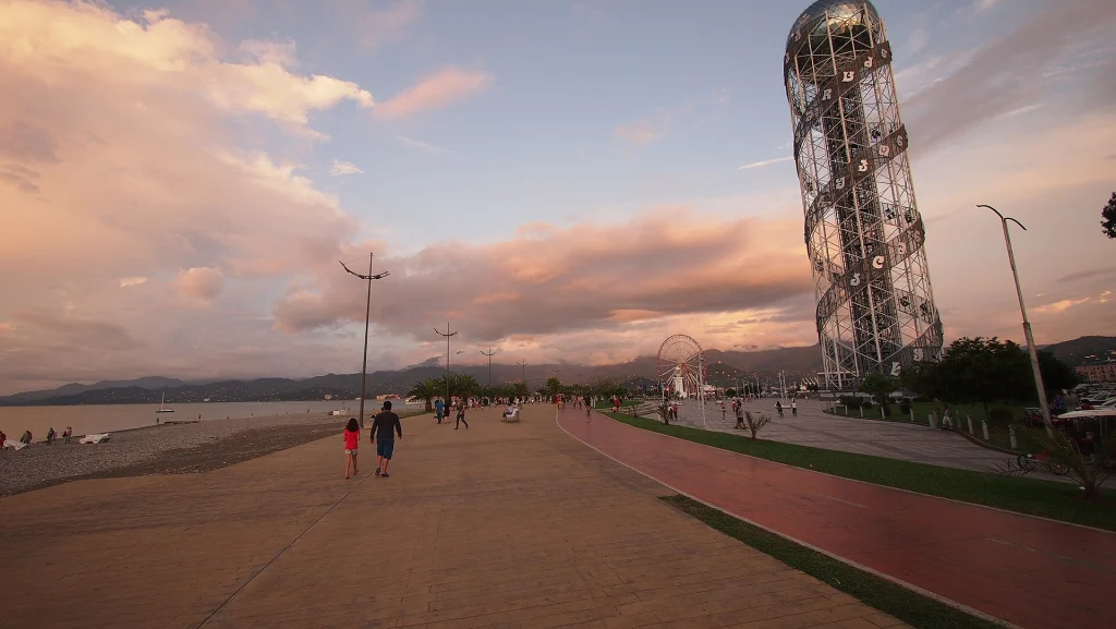 Batumi's seaside promenade at sunset, a popular evening walk for beachgoers.