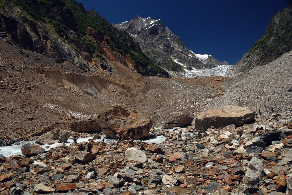 Chalaadi Glacier moraine beneath Mount Chatintau under clear blue sky.