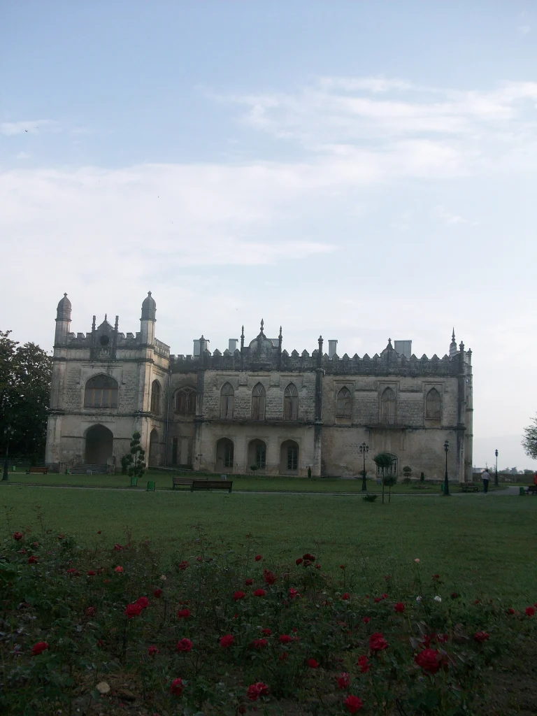 Facade of the Dadiani Palace Museum in Zugdidi with its castellated towers and lawn.