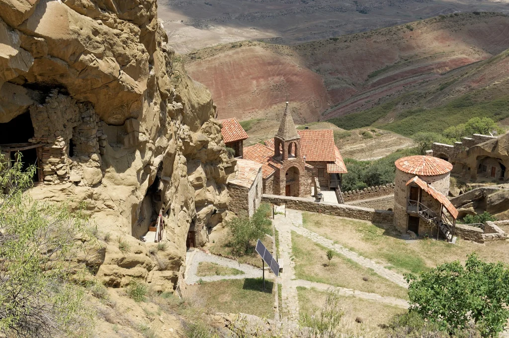 Aerial view of the Lavra monastery complex set among striped semi-desert hills.