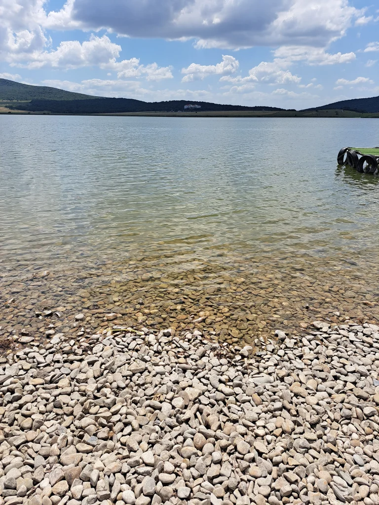 Clear shallow water and pebble shore make Lake Bazaleti a popular swimming spot.