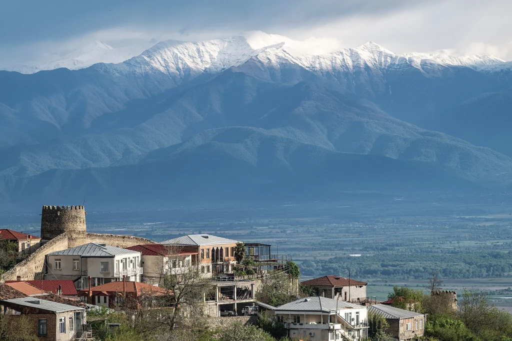Sighnaghi's fortress wall and tower set against the snow-capped Caucasus mountains.