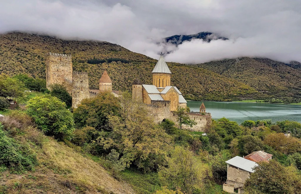 Clouds drift over Ananuri's fortified walls, towers and churches beside the river valley.