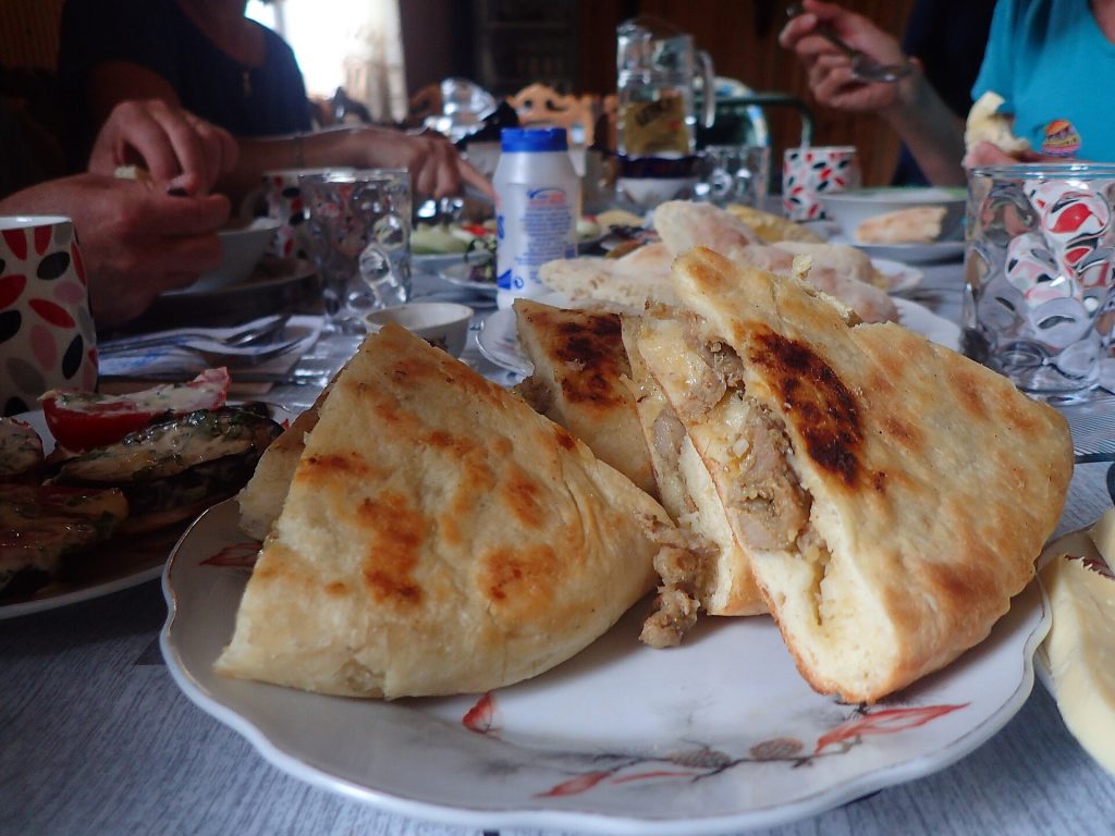 Freshly baked Svan breads served at a table, evoking the shared feasting of Gemo Fest.