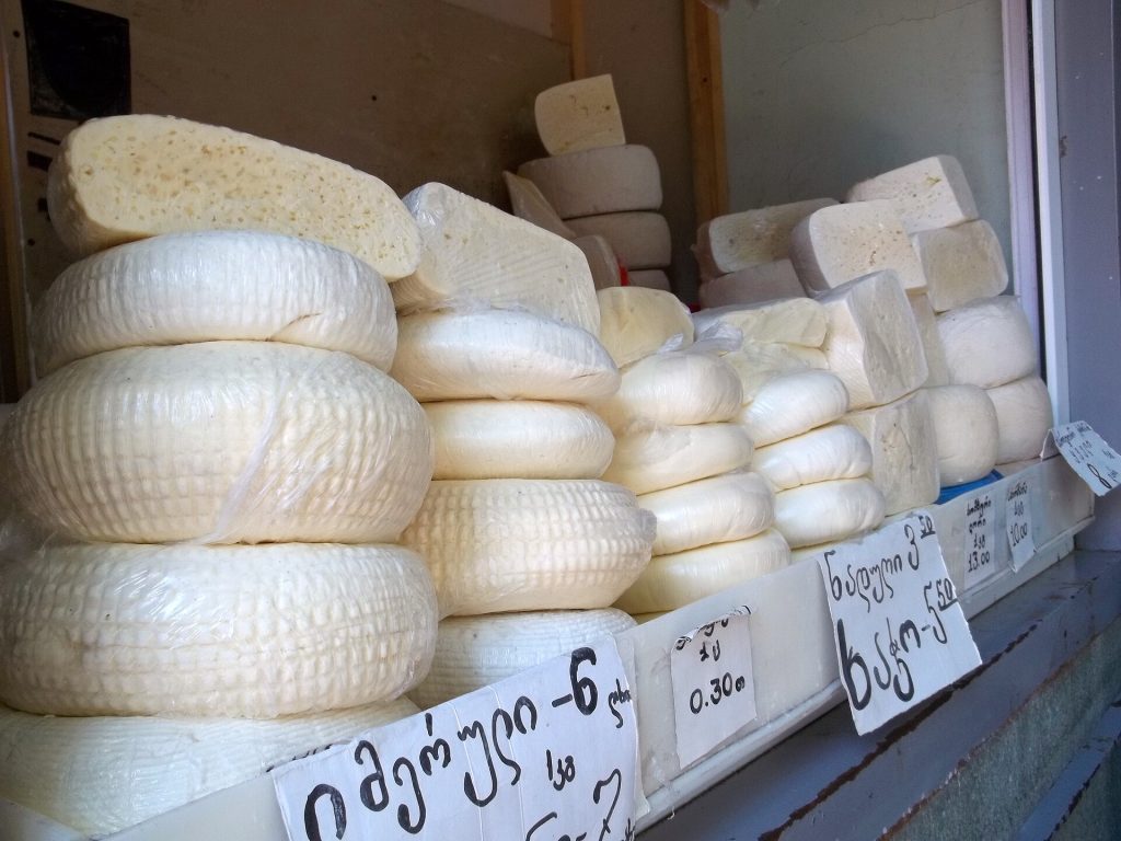 Stacks of traditional Georgian cheeses for sale, a staple of the festival's tastings.